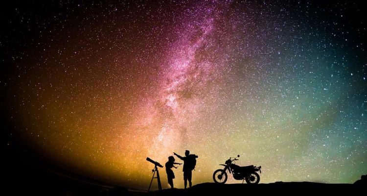In this photo couple watches stars through the telecope
